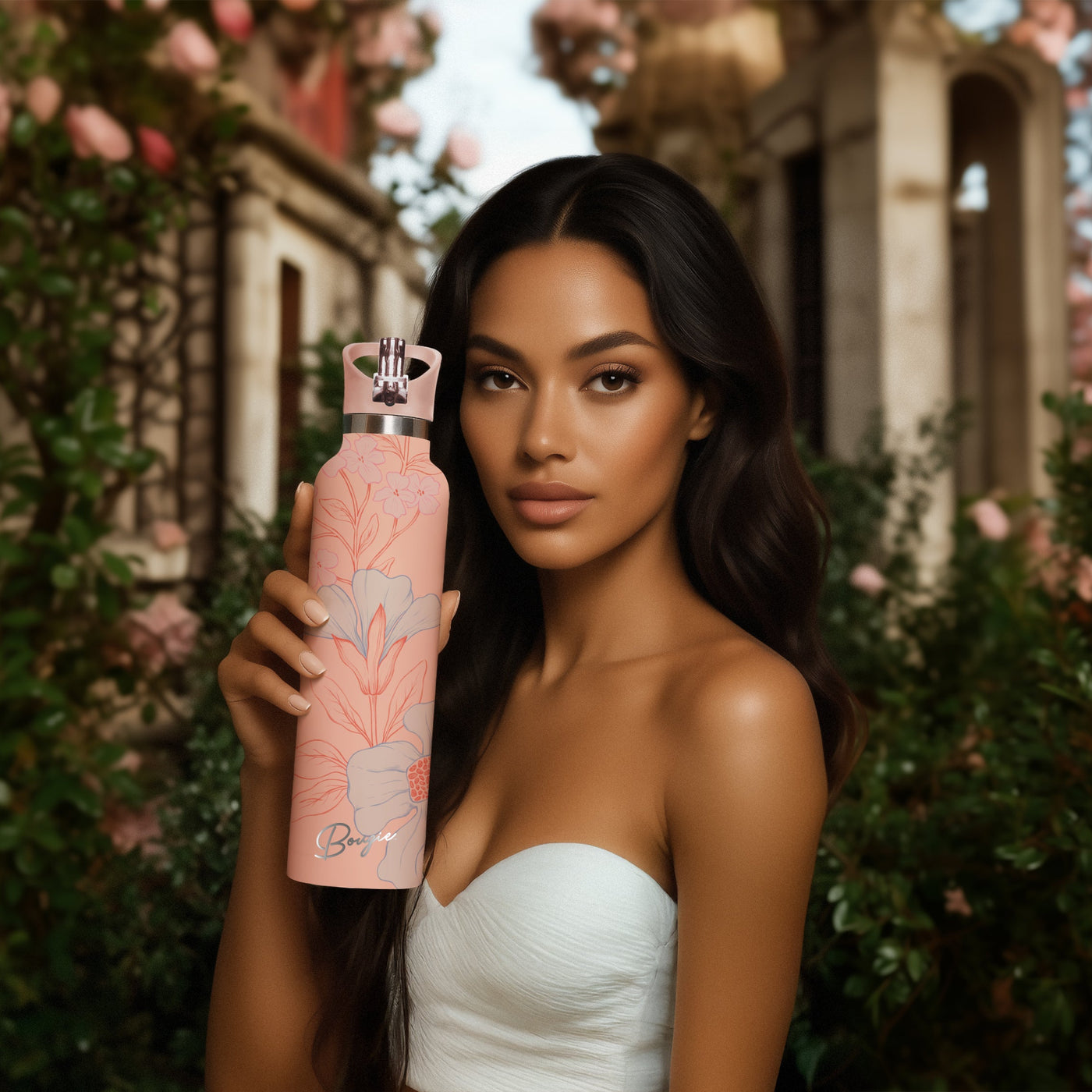 Woman holding a peach water bottle with floral design in a Grecian outdoor setting